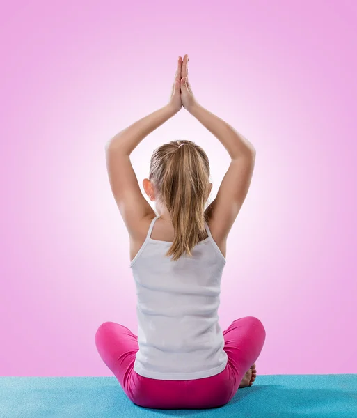 Liten flicka sitter i yogaställning — Stockfoto