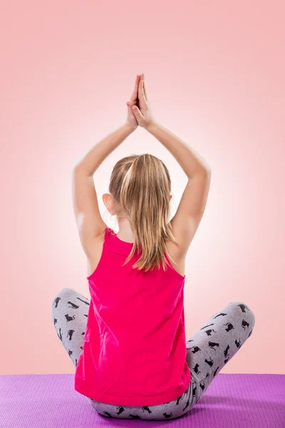 Liten flicka sitter i yogaställning — Stockfoto