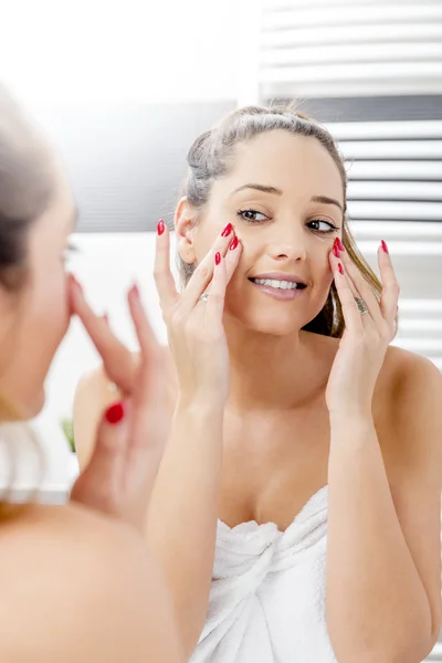 Muchacha atractiva poniendo crema anti-envejecimiento — Foto de Stock