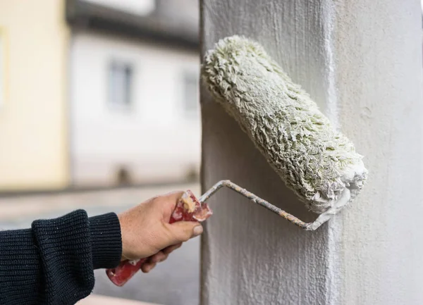 House improvement men with paint roller painting column