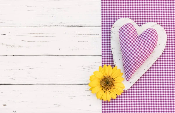 Rustic purple heart with flower on wooden background with copy space