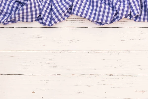 Rustic white wooden table surface with blue checkered cloth, top view