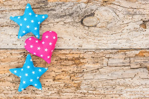 Fabric stars and heart decoration on wooden background with copy space