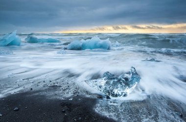 Diamond Beach, Jokulsarlon, İzlanda 'da gün doğumu - Buzdağı ve siyah kum plajı