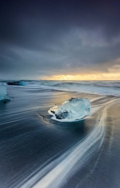 Diamond Beach, Jokulsarlon, İzlanda 'da gün doğumu - Buzdağı ve siyah kum plajı