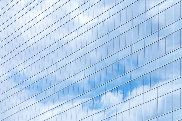 Современные стеклянные окна здания с отражением неба.