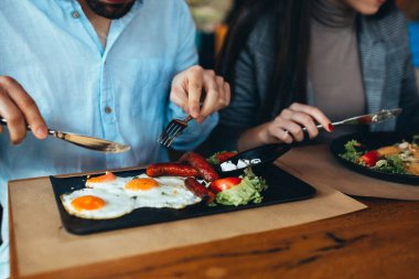 Mutlu çift restoranda ya da yemek köşesinde kahvaltı yapıyor.