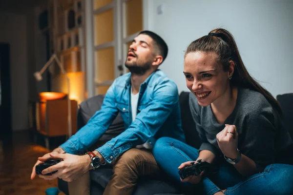 happy couple playing games on game console