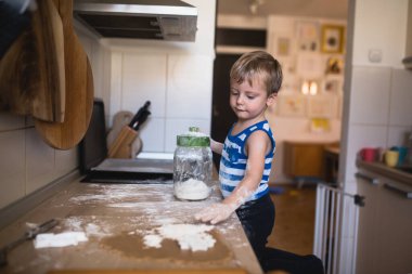 Un ile oynayan ve mutfağı dağıtan sevimli küçük çocuk.