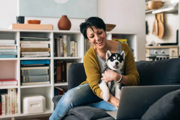 woman playing with her dog at home