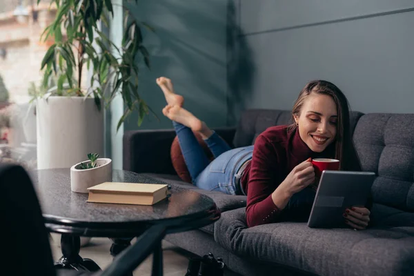 Frau Benutzt Digitales Tablet Während Sie Hause Auf Dem Sofa — Stockfoto