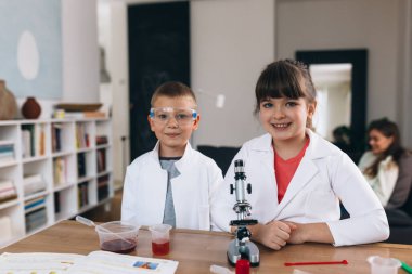 Çocuklar evde mutfak malzemeleriyle kimyasal deneyler yapıyorlar.