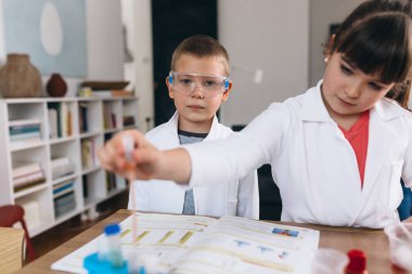 Çocuklar evde mutfak malzemeleriyle kimyasal deneyler yapıyorlar.