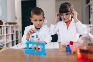 Çocuklar evde mutfak malzemeleriyle kimyasal deneyler yapıyorlar.