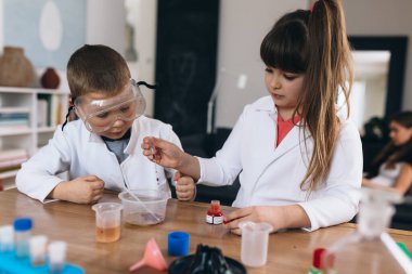 Çocuklar evde mutfak malzemeleriyle kimyasal deneyler yapıyorlar.