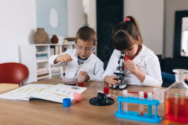 Çocuklar evde kimyasal deneyler yapıyorlar.