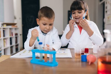 Çocuklar evde kimyasal deneyler yapıyorlar.