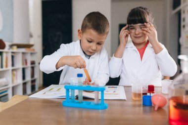 Çocuklar evde kimyasal deneyler yapıyorlar.