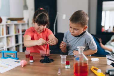 Erkek ve kız kardeş evde kimyasal deneyler yapıyorlar.