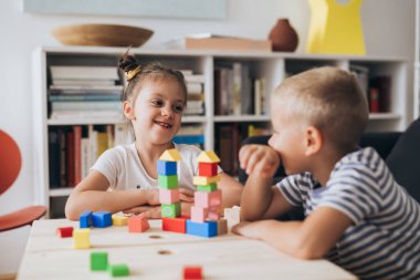 Mutlu küçük çocuklar evde oynuyorlar.