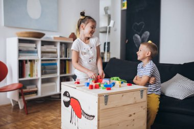 Mutlu küçük çocuklar evde oynuyorlar.