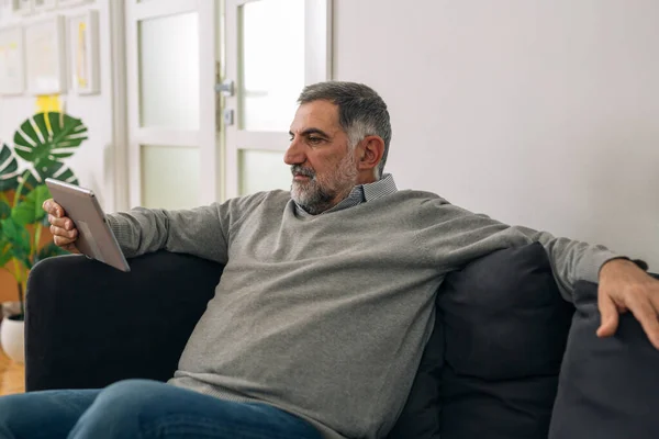 Man Sitting Sofa His Home Using Digital Tablet — Stock Photo, Image