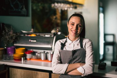 Garson kafeteryasında kollarını kavuşturdu.