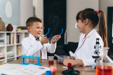 Çocuklar evlerinde kimyasal deneyler yapıyorlar.