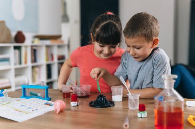 Erkek ve kız kardeş evde kimyasal deneyler yapıyorlar.