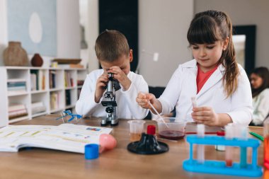 Erkek ve kız kardeş evde kimyasal deneyler yapıyorlar.