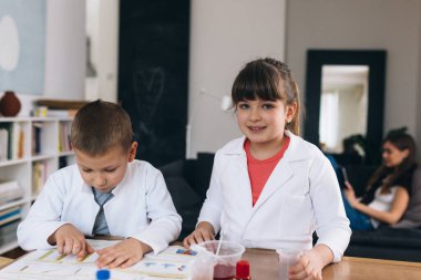 Erkek ve kız kardeş evde kimyasal deneyler yapıyorlar.