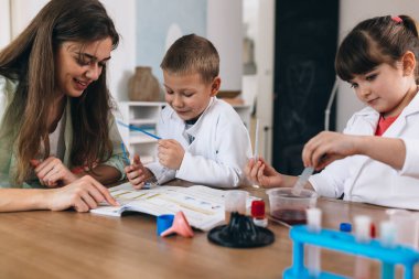 Çocuklar evde kimyasal deneyler yapıyorlar.