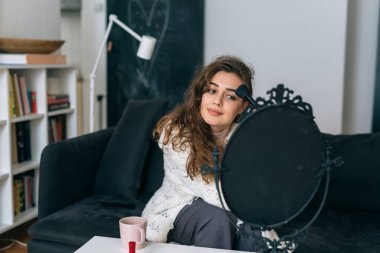 Evinde makyaj yapan bir kadın.