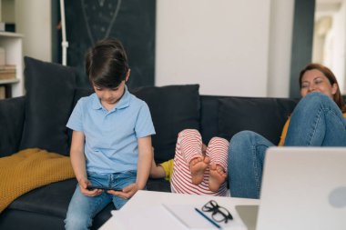 Çocuk evde cep telefonu kullanıyor.