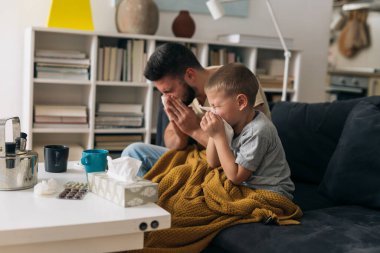 Baba ve oğul üşütürler. Evde hasta oturuyorlar.