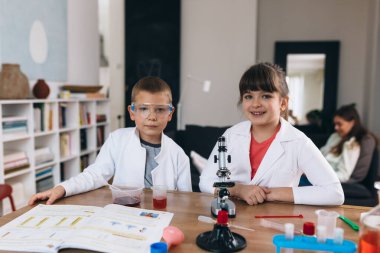 Erkek ve kız kardeş evde kimyasal deneyler yapıyorlar.