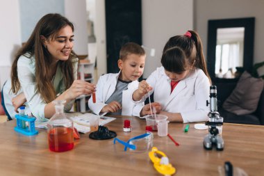 Erkek ve kız kardeş evde kimyasal deneyler yapıyorlar.