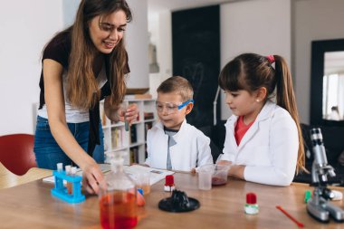 Erkek ve kız kardeş evde kimyasal deneyler yapıyorlar.