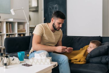 Küçük çocuk grip olmuş. Babası ateşini ölçtü.