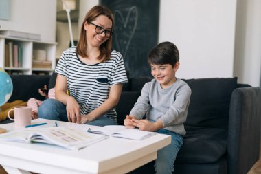 Anne ve oğlu evde ödev yapıyor.