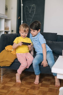 Çocuklar evde akıllı telefon kullanıyor.