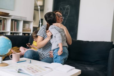 Anne, oğluna ödevlerinde yardım ediyor.
