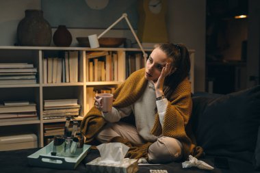 Çay içen soğuk bir kadın. Şu anda evinde oturuyor.