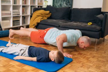Baba oğul evde antrenman yapıyor. Karantina kavramı.