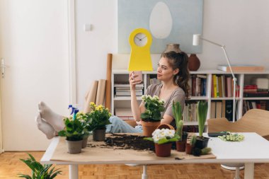 Evinde bahçeyle uğraşan bir kadın.