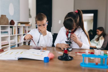 Çocuklar evde kimyasal deneyler yapıyorlar.