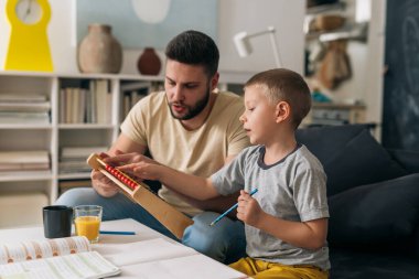 Baba oğluna ödevlerinde yardım ediyor.