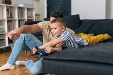 baba ve oğul evde video oyunu oynuyorlar.