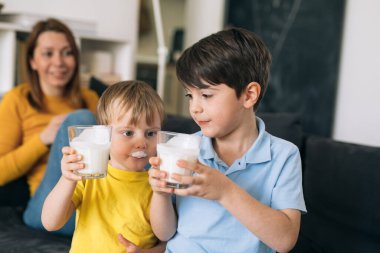 Küçük çocuklar evde süt içiyorlar.