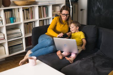 Anne oğluyla dizüstü bilgisayar kullanıyor. evde.